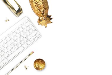 Ofis masası ve beyaz masa üzerinde kadın nesneleri. Düz yatıyordu. Altın ananas, altın zımba, kalem. Modanın natürmortu