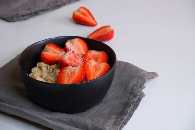 Çilekli yulaf ezmesi. Lezzetli bir kahvaltı. Yemek pişirmek. Lapa.