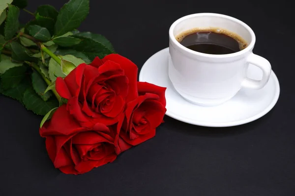 Coffee and roses on a black background. Flowers.