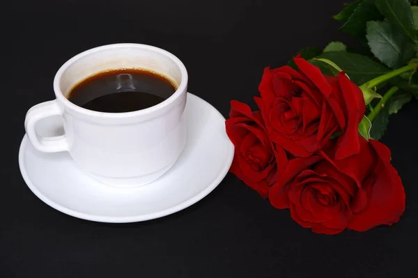 Coffee and roses on a black background. Flowers.