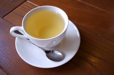 Ahşap arka planda bir fincan yeşil çay..