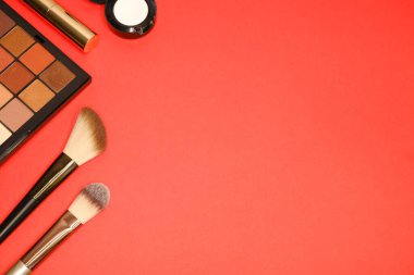 Kırmızı arka planda kozmetik ürünler. Makyaj.