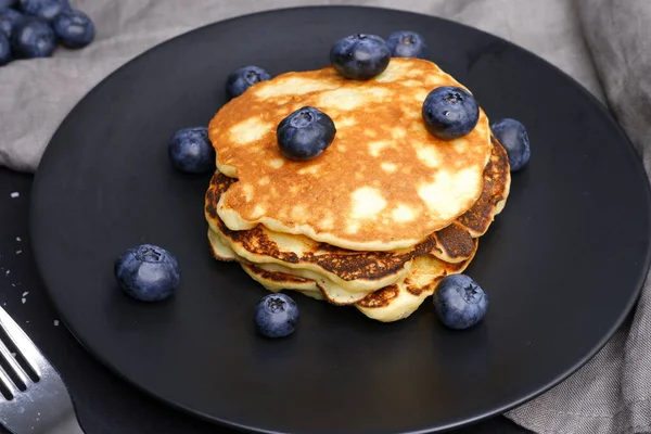 Pancake Dengan Blueberry Latar Belakang Hitam Dan Piring Hitam — Stok Foto