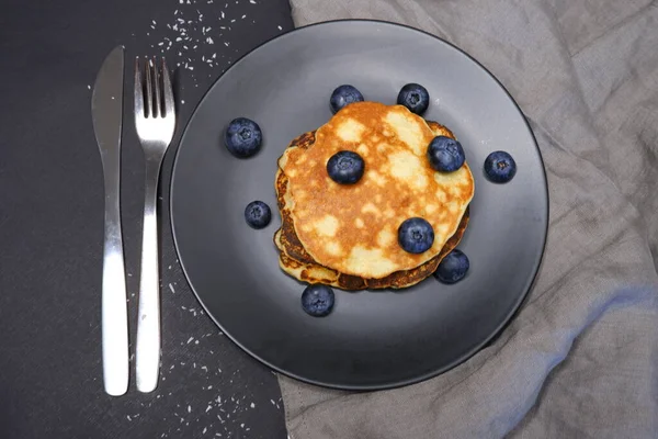 Pancake Dengan Blueberry Latar Belakang Hitam Dan Piring Hitam — Stok Foto