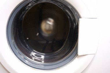 Çamaşır makinesi çalışıyor. Beyaz şık ev aletleri.