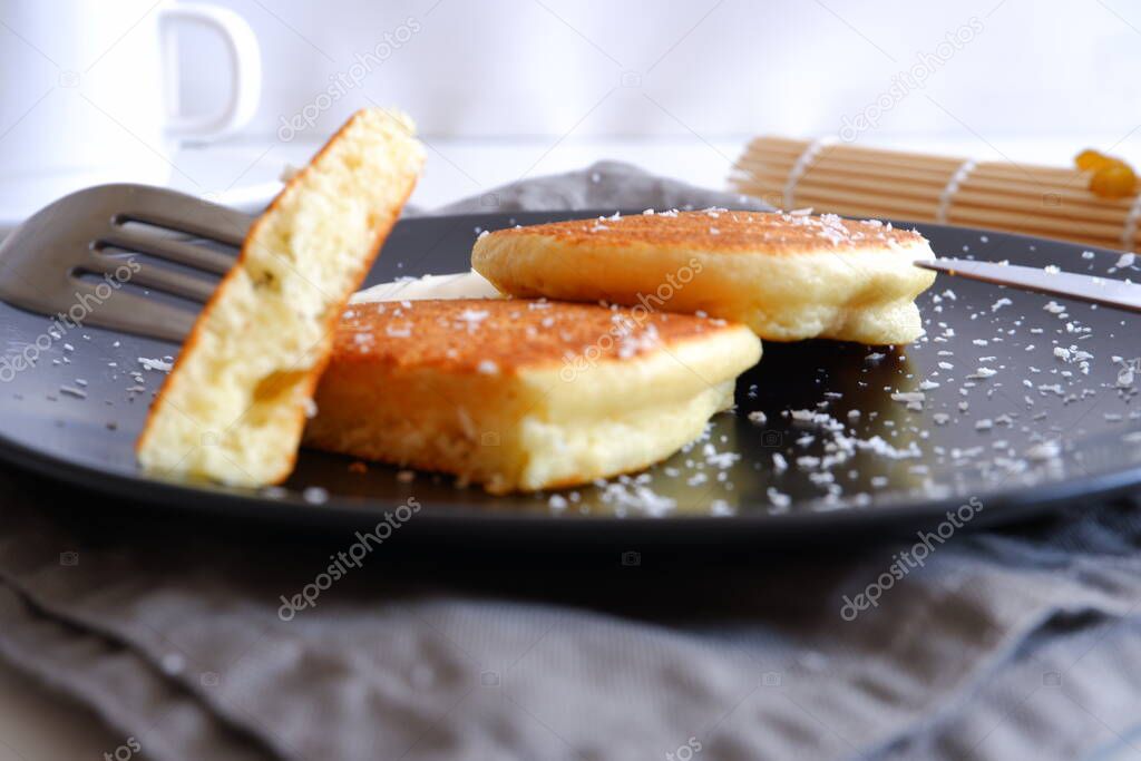 Semolina pancakes in a black plate.