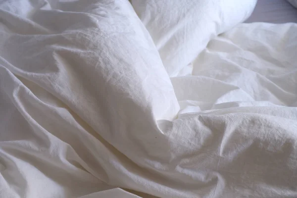 White bed linen texture. Suitable for backgrounds. Interior. Bed