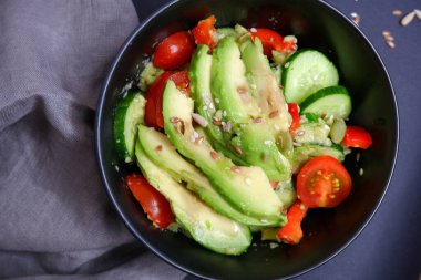 Avokado, domates ve salatalıklı sebze salatası. Yiyecekler. Yemek pişirme.