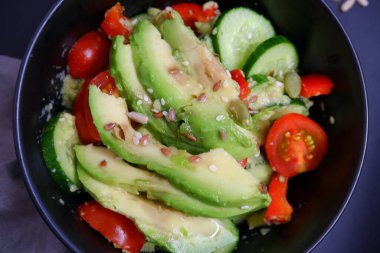 Avokado, domates ve salatalıklı sebze salatası. Yiyecekler. Yemek pişirme.
