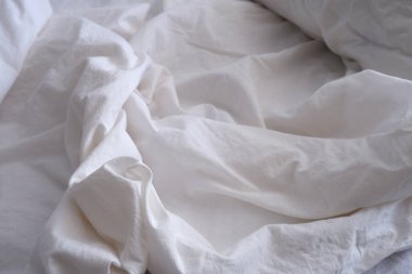 Yatak örtüsü dokusu. Beyaz çarşaf arka planı. Yatağa. İç mekan.