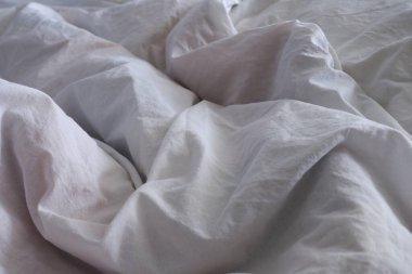 Yatak örtüsü dokusu. Beyaz çarşaf arka planı. Yatağa. İç mekan.