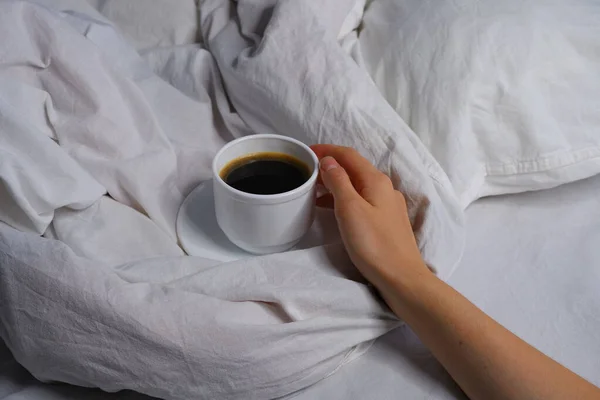 女孩抱着一杯咖啡在床上 早餐在床上 — 图库照片