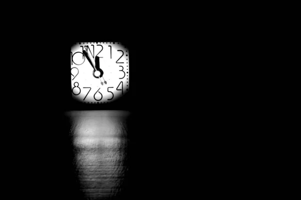 Masa Saatinin Siyah Beyaz Görüntüsü Önplanda Bulanıklık Işık Demeti Ile — Stok fotoğraf