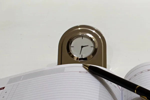 Relógio Mesa Metal Com Diário Caneta Esferográfica Sobre Fundo Branco — Fotografia de Stock
