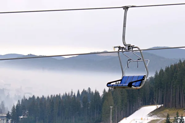 空のスキーリフトの座席が霧の中の山の風景の背景にぼやけて — ストック写真