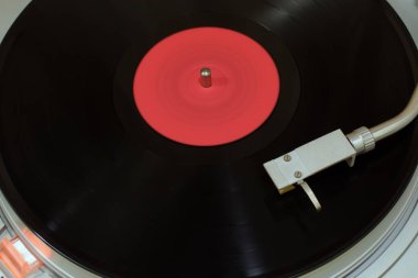 Hareket üzerindeki turntable başı vinil kaydın bulanık arkaplanını bulanıklaştırdı