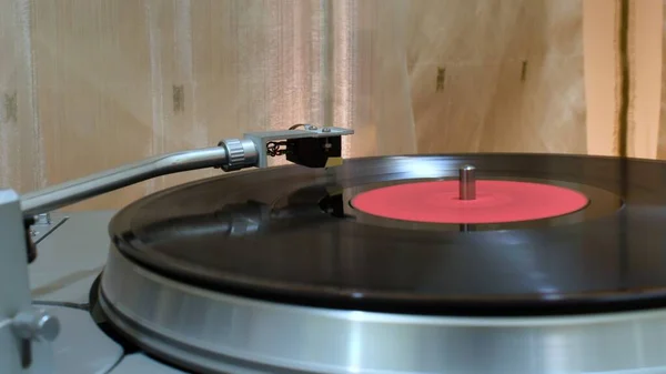 Hareket üzerindeki turntable başı vinil kaydın bulanık arkaplanını bulanıklaştırdı
