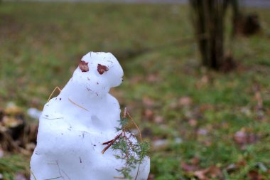 Baharda yeşil parkın bulanık arka planında erimiş kardan adam