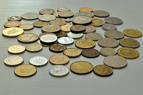 Farklı ülkelerin sikkeleri ve boyalı masadaki mezhepler