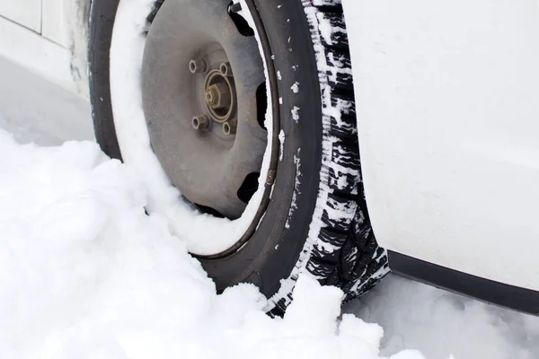 car wheel with winter tread in deep snow close-up. focus in center of image