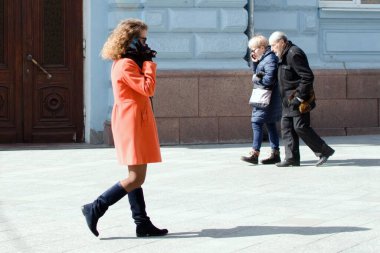Ukraine Zhytomyr March 26, 2021. Youth and old age. Beautiful young girl walking towards elderly woman and man on the street