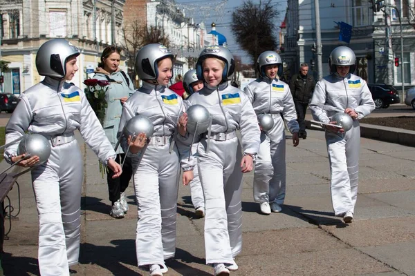 Kozmonotlar gününde şehir sokaklarında yürüyen taklitçi astronotların kostümleri içindeki gençler. Ukrayna Zhytomyr 12 Nisan 2021