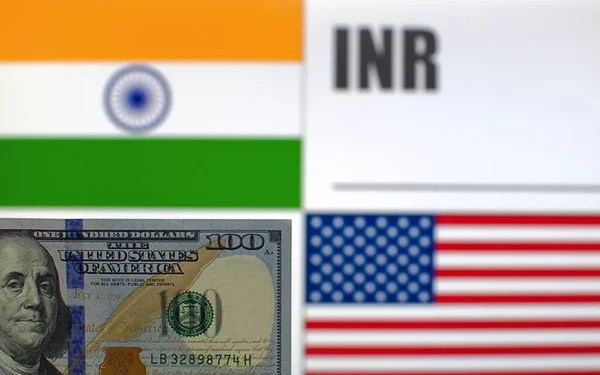 100 US dollars banknote on blurred background of India and USA flags and currency code of India. Exchange rate template