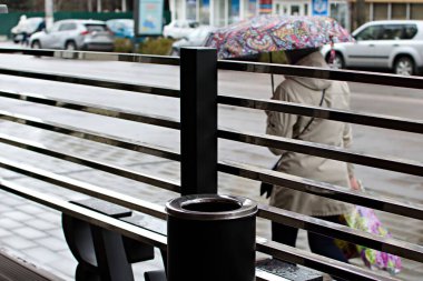 Şehir caddesinin bulanık arka planı yağmurlu bir günde açık kafenin metal çitlerinden geçiyor. Ukrayna Zhytomyr 21 Nisan 2021