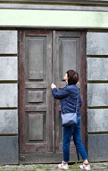 女人打开门 抬头看着空荡荡的标牌 废弃房屋的旧木门 — 图库照片