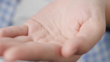 İçinde yeşil toz bulunan iki büyük şeffaf silindirik hap kapsülü ilaç şişesinden avuç içine düşer. Yakın çekim, ön görüntü, merkez kompozisyon