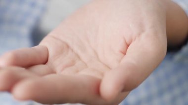 Ortalama iki tane beyaz yuvarlak hap ilaç şişesinden avuç içine düşer. Yakın çekim, ön görüntü, merkez kompozisyon