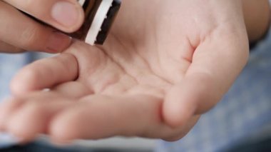 İki büyük pembe yuvarlak şekil ilaç şişesinden avuç içine düşer. Yakın çekim, ön görüntü, merkez kompozisyon