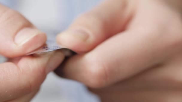 De menselijke vinger perst de pil uit het pakket. Close-up, vooraanzicht — Stockvideo