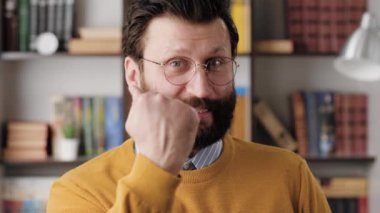 Evet, duygusal bir jest. Ofisinde ya da dairesinde gözlüklü neşeli sakallı adam kameraya bakıyor ve elini yumruk yapıp memnuniyetini ve muhtemelen zaferini gösteriyor.