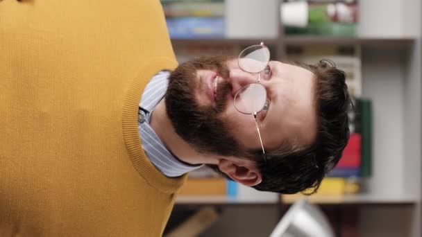 Кричіть НІ, зупиніться. Вертикальне відео засмученого бородатого чоловіка в окулярах в офісі або квартирі дивиться на камеру і в люті нервово кричить NO. Крупним планом і повільний рух — стокове відео