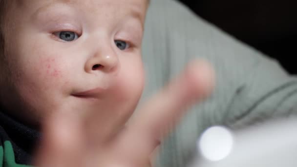 Dítě si hraje s telefonem. Detailní záběr legrační tvář malého roztomilé dítě 2-3 let, který klikne na obrazovce smartphone. Zpomalený pohyb — Stock video