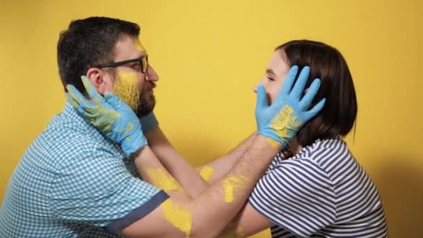 絵画の壁 改装室 仕事の終わりを祝う 幸せなカップルの男性と女性が喜んでキスと抱擁 新しく塗装黄色の壁を見てください スローモーション — ストック動画