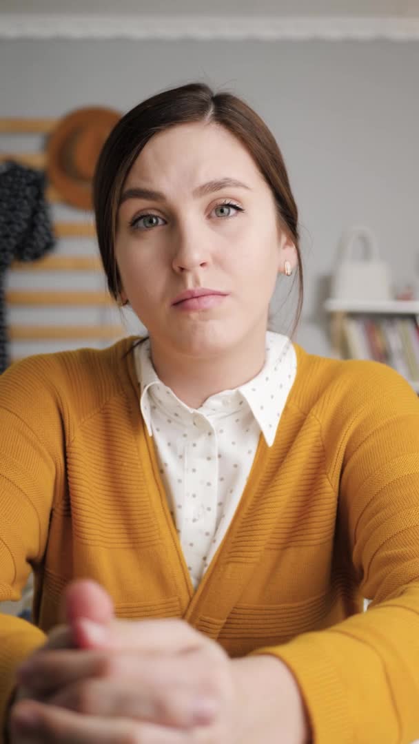 Online leren, online vergaderen, afstandsonderwijs concept. Verticale video van de vrouw in gele trui in de slaapkamer zit aan tafel kijken naar de camera en luistert aandachtig naar gesprekspartner op video oproep — Stockvideo