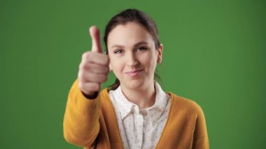 Başparmağını kaldır. Krom anahtarlı olumlu gülümseyen kadın kameraya bakıyor ve baş parmağını kaldırıyor. Yavaş çekim