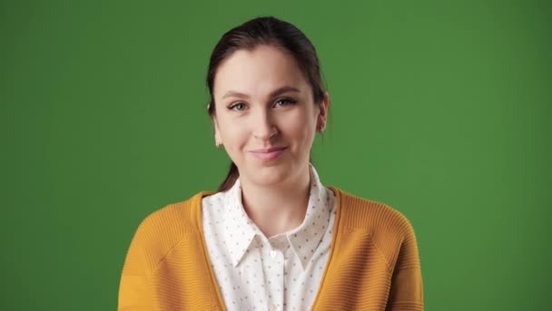 Een vrouw wijst naar iemand. Positieve lachende vrouw op chroma key achtergrond die naar de camera kijkt en met haar vinger naar iemand wijst. Langzame beweging — Stockvideo