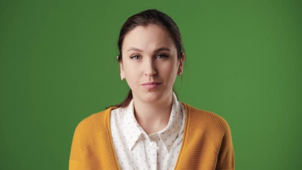 A mulher concorda. Mulher positiva no fundo da chave chroma olhando para a câmera e acena com a cabeça positivamente, sinalizando SIM. Movimento lento — Vídeo de Stock