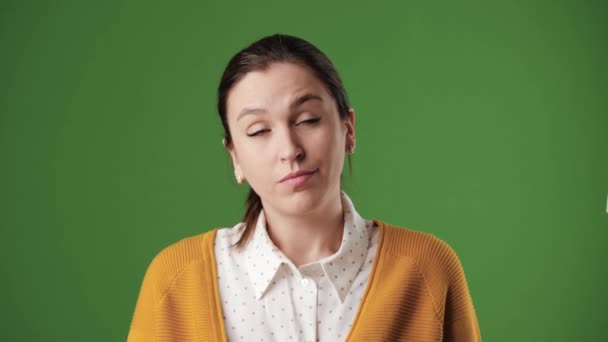 FACEPALM in Verbindung setzen. Verblüffte Frau auf grünem Hintergrund mit Chroma-Taste blickt in die Kamera und bedeckt ihr Gesicht mit seiner Handfläche, die ihre Fassungslosigkeit ausdrückt. Zeitlupe — Stockvideo