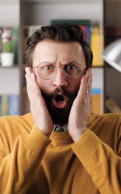 Adam şaşırdı, şok oldu. Ofiste ya da apartman dairesinde gözlüklü, gülümseyen sakallı bir adam kameraya bakıyor ve inanılmaz şaşkınlığını ifade etmek için ellerini sallıyor. Görüntüyü kapat