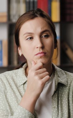 Kadın düşüncesi, beyin fırtınası, iyi fikir. Ofiste yoğunlaşmış bir kadın ya da düşünceli bir yüzü olan bir apartman dairesi. Etrafına bakıp beyin fırtınası yapıyor. Orta ekran görüntü