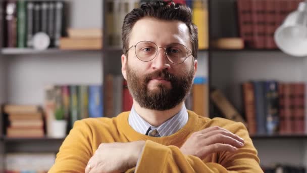 Retrato de homem com óculos. Tiro médio de homem barbudo bonito com óculos olhando para a câmera e sorrindo, câmera amplia lentamente. Movimento lento — Vídeo de Stock