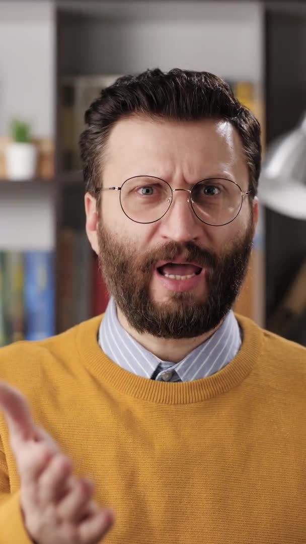 Surprised man. Vertical video of indignant bearded male teacher or businessman with glasses looks at camera and says HEY, WHAT. Slow motion — Stock Video