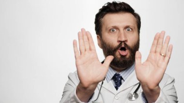 Doktor hayır diyor, anlaşmazlık, dur. Beyaz arka planda korkmuş endişeli bir doktor kameraya bakıyor ve iki avuç içi kamerayla HAYIR diyor.
