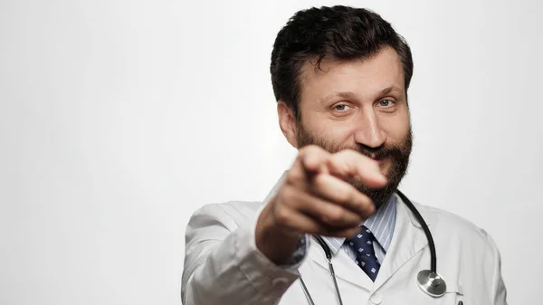 닥터가 손가락을 가리키고 배경에 미소짓는 의사가 카메라를 손가락을 카메라에 — 스톡 사진