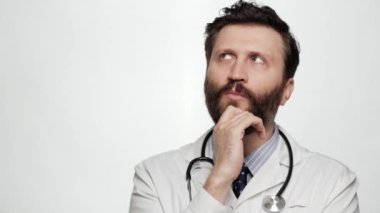 Doktor düşüncesi, beyin fırtınası. Beyaz arka planda, etrafınıza bakıp beyin fırtınası yapan, düşünceli, konsantre bir doktor portresi.