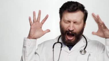 Komik deli doktor korkmuş, korkmuş. Beyaz arka planda korkmuş adam doktor kameraya bakıyor ellerini kaldırıyor ve bağırıyor, çok korkmuş ve dehşete düşmüş durumda.